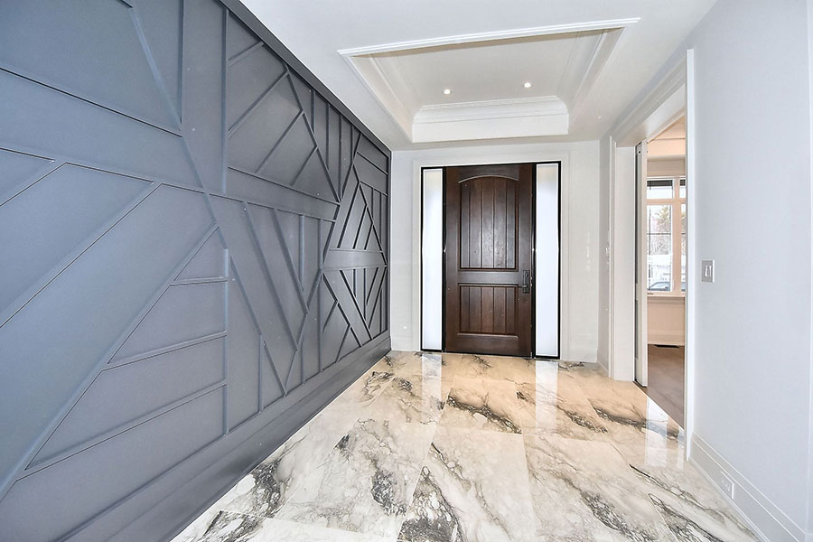 Modern Entryway with Geometric Accent Wall and Marble Floors