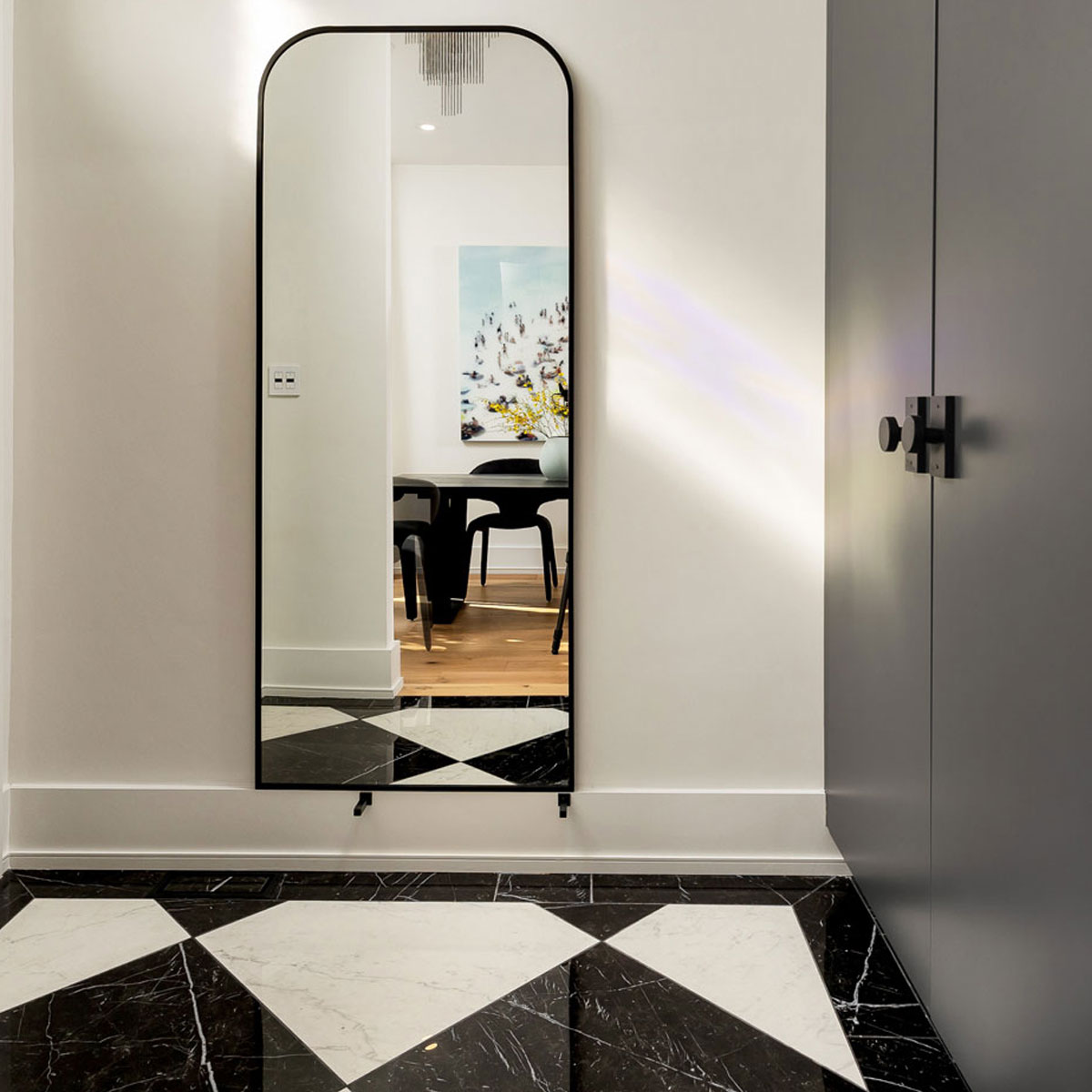 Elegant entryway with black and white geometric flooring